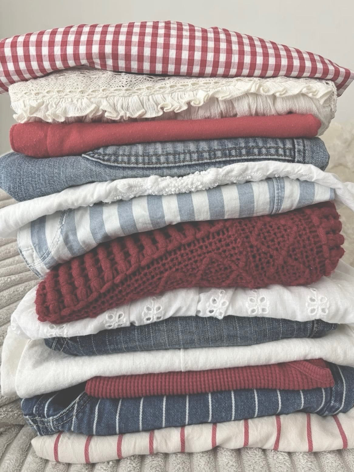 Folded stack: red gingham, cream eyelet, rust ribbed knit, light denim, blue and white ticking stripe.