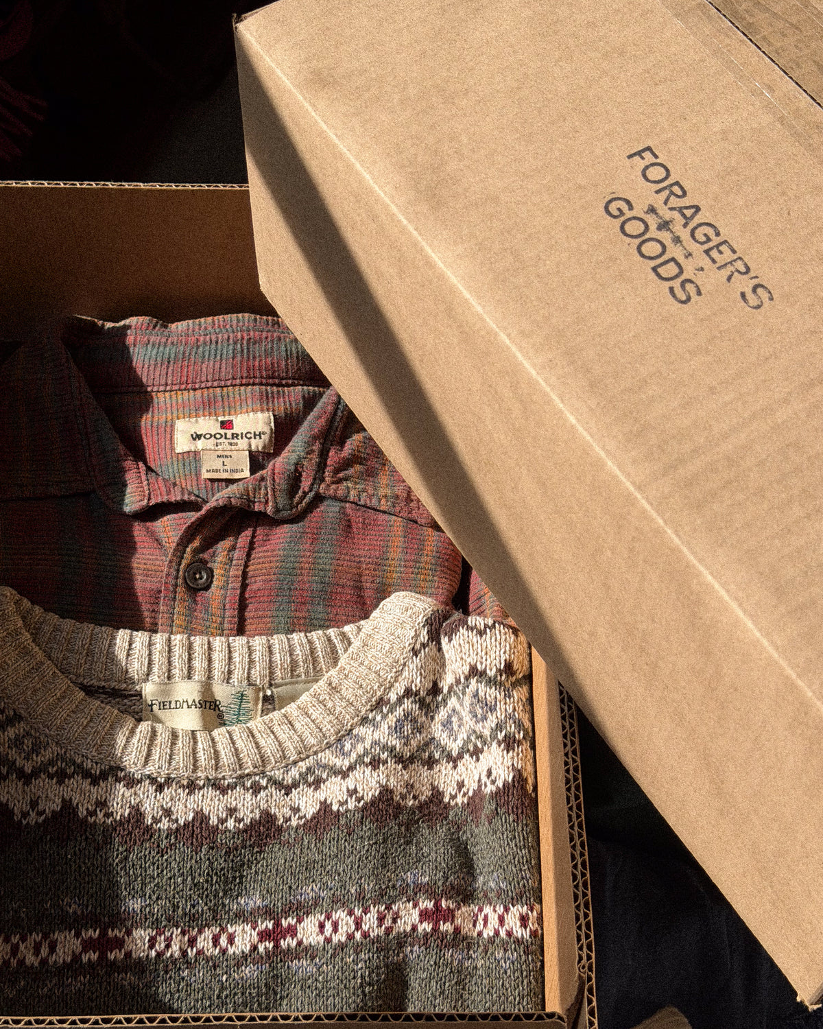 Vintage plaid flannel and a cream fair isle knit packed in a Forager's Goods shipping box